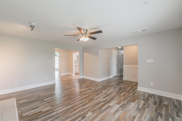 empty room with wood finished floors, visible vents, baseboards, and ceiling fan