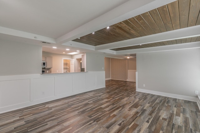 unfurnished living room with wood finished floors, a wainscoted wall, beam ceiling, visible vents, and recessed lighting