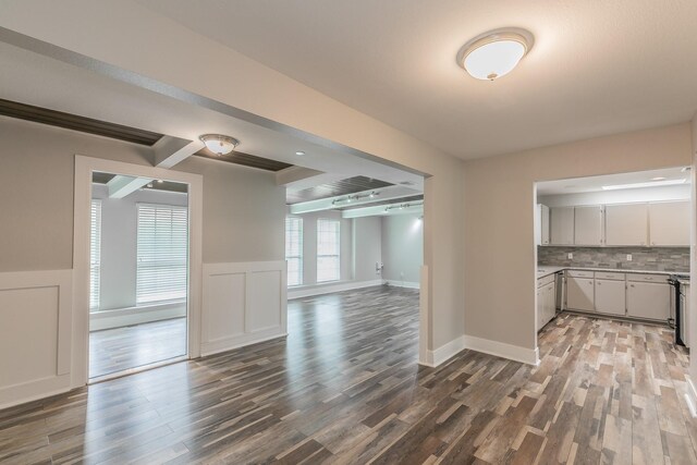 interior space featuring wood finished floors, a decorative wall, and wainscoting