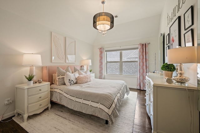 bedroom featuring baseboards, a notable chandelier, and wood finished floors