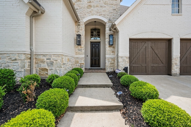 doorway to property with stone siding and concrete driveway