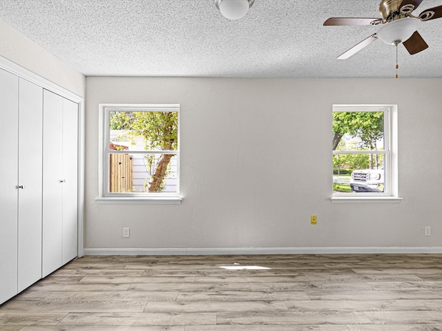 13514 Onyx Ln, Farmers Branch, TX 75234 - unfurnished bedroom featuring light wood finished floors, a closet, and multiple windows