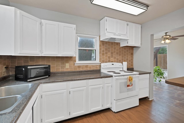 kitchen with white cabinets, dark countertops, a ceiling fan, under cabinet range hood, and white electric range