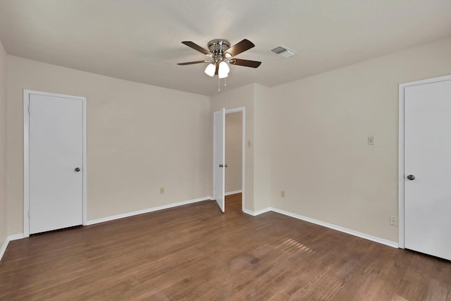 unfurnished room featuring visible vents, a ceiling fan, baseboards, and wood finished floors
