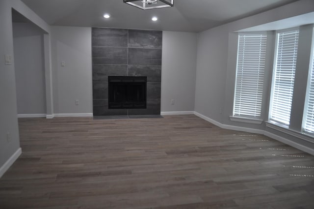 unfurnished living room with recessed lighting, wood finished floors, a fireplace, and baseboards