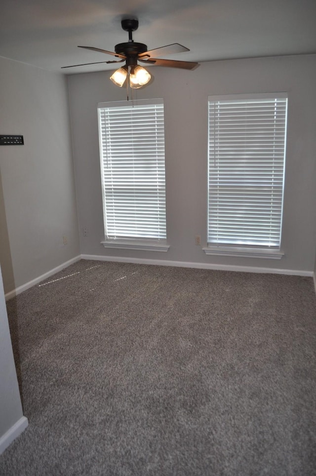 carpeted empty room with ceiling fan and baseboards