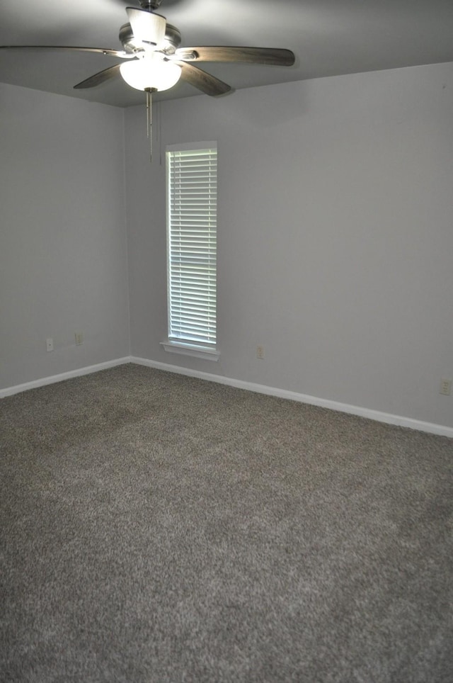 carpeted spare room with ceiling fan and baseboards