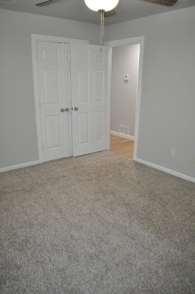 spare room with carpet, visible vents, and baseboards