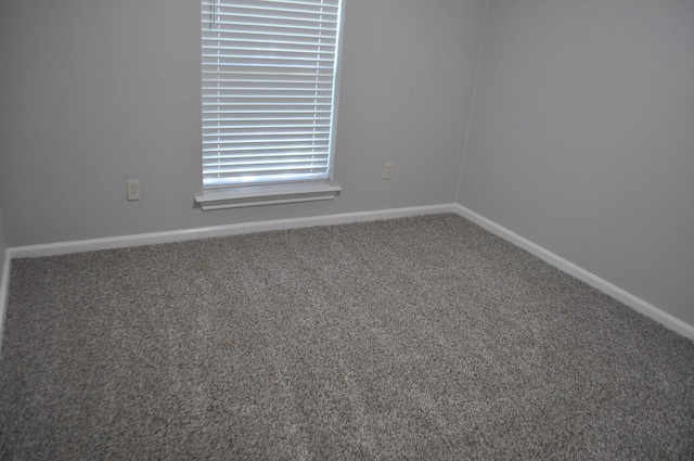 empty room with baseboards and carpet