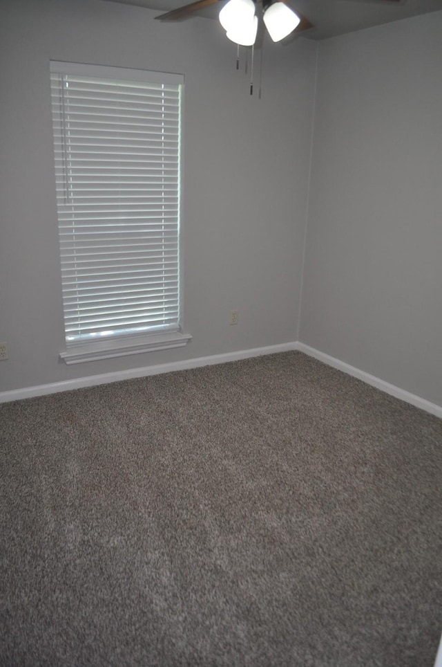 carpeted empty room with ceiling fan and baseboards