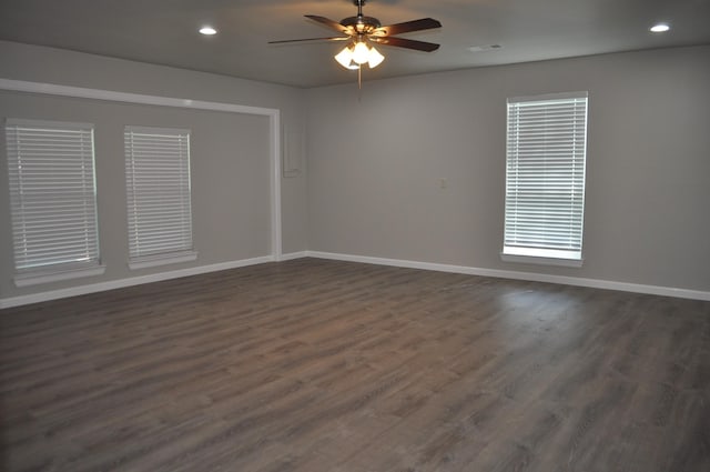empty room featuring dark wood-type flooring, baseboards, and ceiling fan