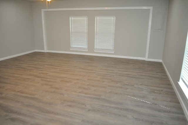 spare room featuring baseboards and wood finished floors