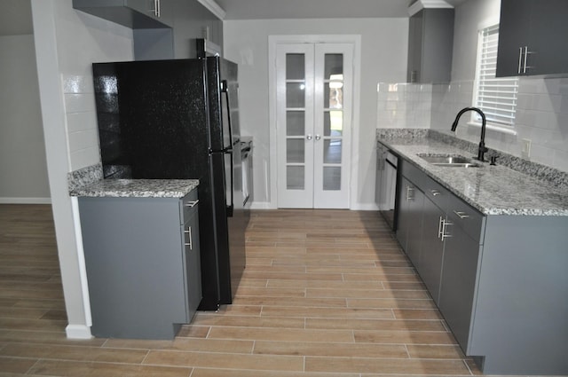 kitchen with gray cabinets, a sink, wood tiled floor, and freestanding refrigerator