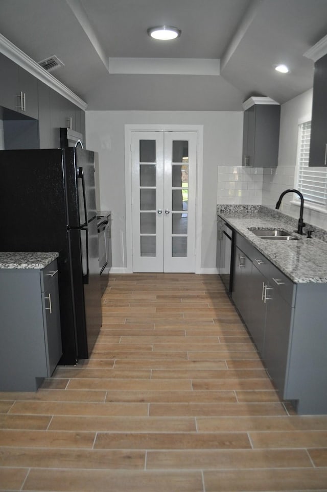 kitchen featuring french doors, a sink, light wood-style floors, gray cabinetry, and black appliances