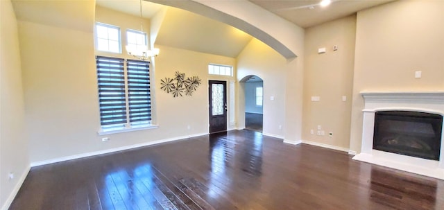 1107 Brooklyn Dr, Anna, TX 75409 - unfurnished living room with hardwood / wood-style flooring, a glass covered fireplace, arched walkways, baseboards, and a notable chandelier