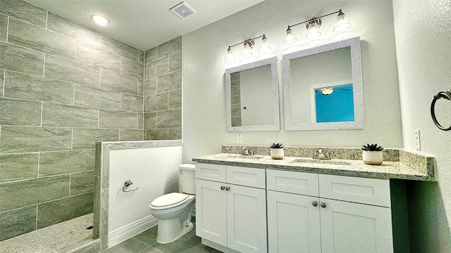full bath featuring double vanity, visible vents, toilet, a walk in shower, and a sink