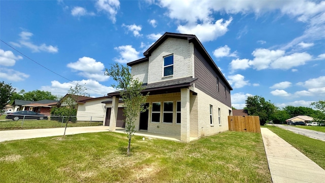 view of front facade featuring fence, driveway, brick siding, and a front yard