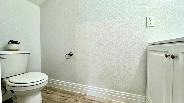 bathroom featuring wood finished floors, toilet, and baseboards
