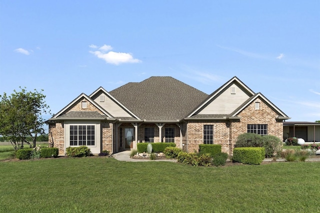 craftsman-style house featuring brick siding and a front yard