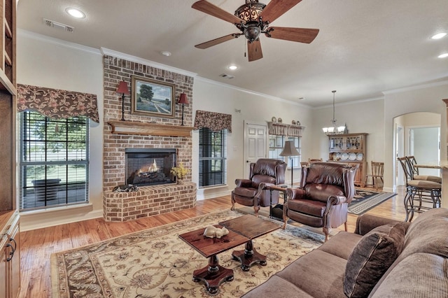 living area featuring ceiling fan with notable chandelier, wood finished floors, and visible vents