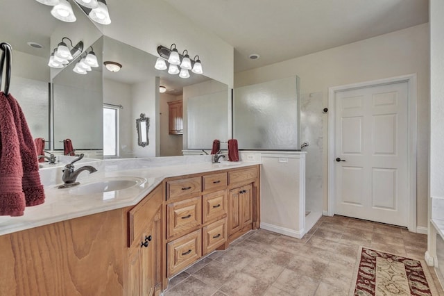 bathroom featuring baseboards, a sink, a walk in shower, and double vanity