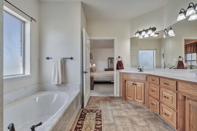 ensuite bathroom featuring a garden tub, vanity, and connected bathroom