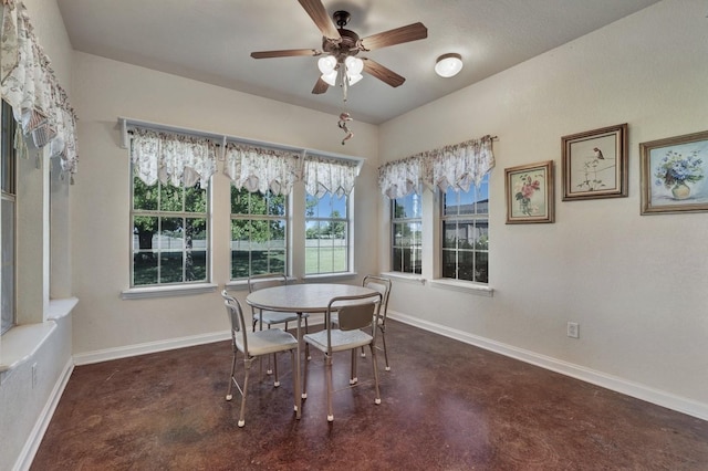 dining area with baseboards, concrete flooring, and ceiling fan