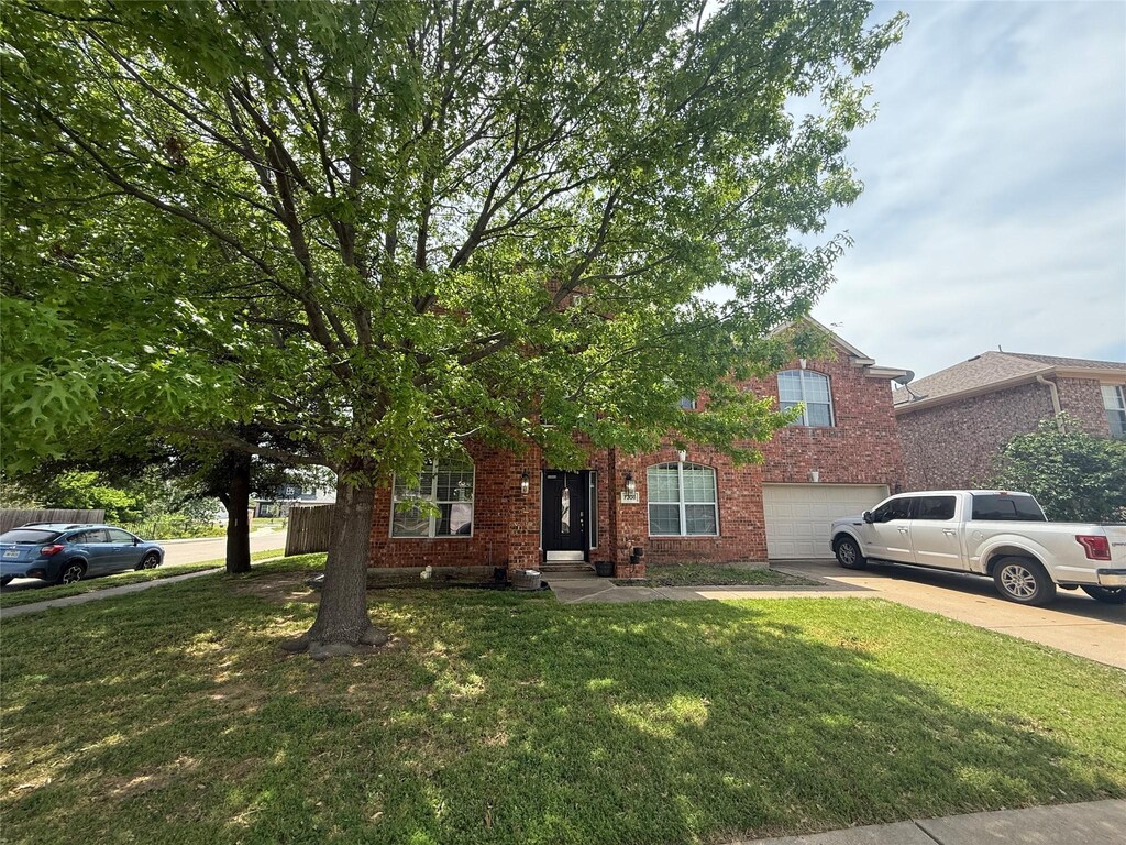 7308 Circle Dr, North Richland Hills, TX 76180 - view of property hidden behind natural elements featuring an attached garage, driveway, a front lawn, and brick siding