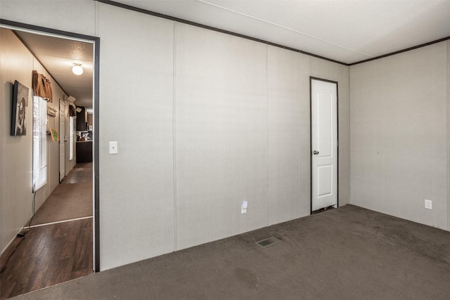 unfurnished room with wood finished floors and visible vents