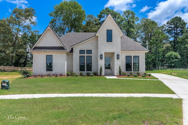 831 Walstonburg Ln, Benton, LA 71006 - view of front of home featuring brick siding, a front lawn, board and batten siding, and a shingled roof