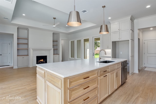 831 Walstonburg Ln, Benton, LA 71006 - kitchen with a tray ceiling, crown molding, light wood-type flooring, a warm lit fireplace, and dishwasher
