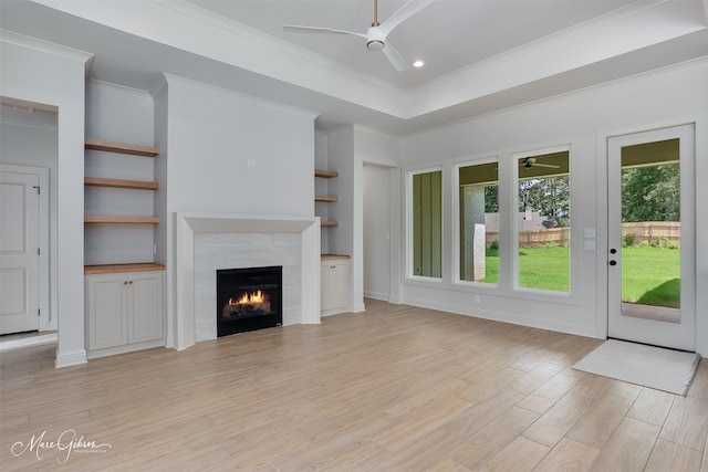 831 Walstonburg Ln, Benton, LA 71006 - unfurnished living room with ceiling fan, light wood-style flooring, a tiled fireplace, crown molding, and built in features