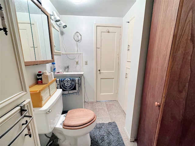 half bathroom featuring toilet and baseboards