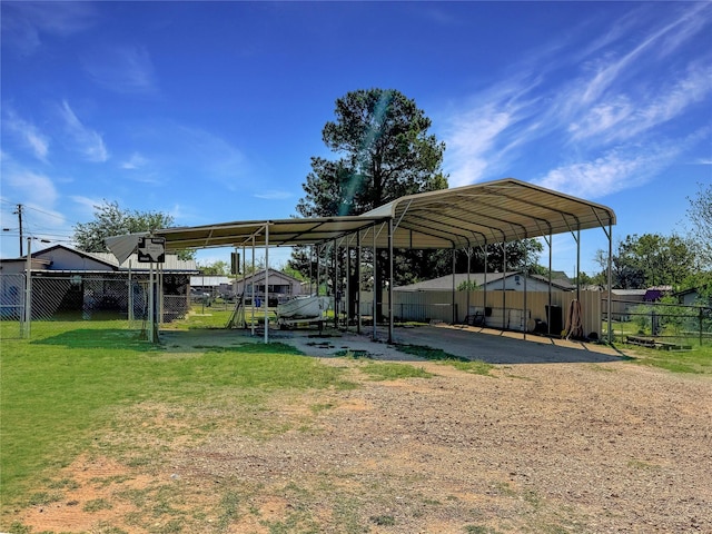 view of vehicle parking featuring fence, driveway, and a detached carport