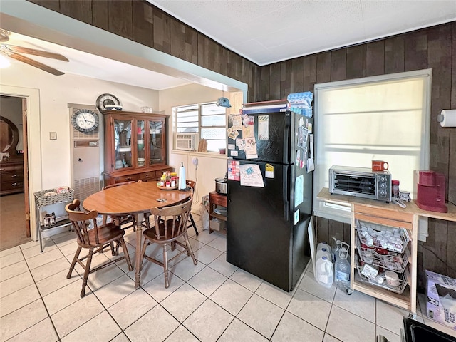 dining room with cooling unit, light tile patterned floors, ceiling fan, a toaster, and wood walls