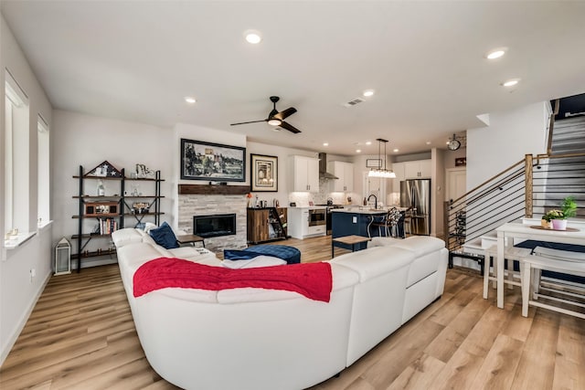 720 Bandera Ct, Prosper, TX 75078 - living area featuring light wood finished floors, recessed lighting, stairs, ceiling fan, and a stone fireplace