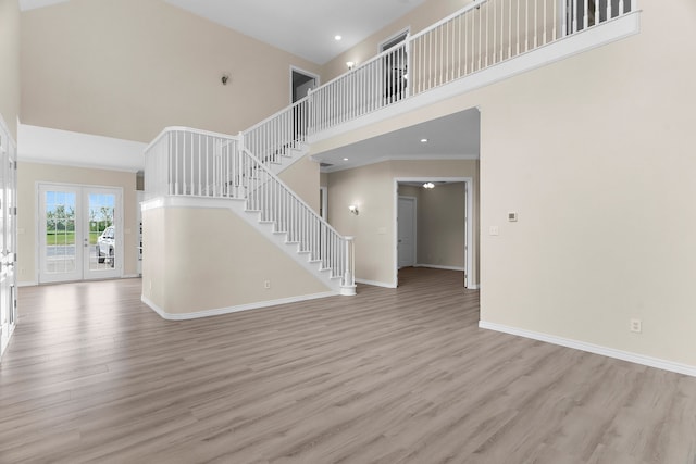 1991 Sunset Trl, Mckinney, TX 75071 - unfurnished living room featuring light wood finished floors, baseboards, recessed lighting, a high ceiling, and stairway