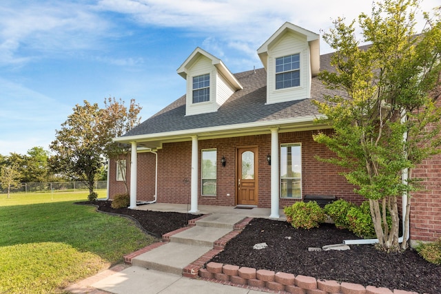 1991 Sunset Trl, Mckinney, TX 75071 - view of front of property with fence, a porch, a front yard, brick siding, and roof with shingles