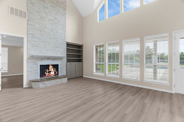 1991 Sunset Trl, Mckinney, TX 75071 - unfurnished living room featuring high vaulted ceiling, wood finished floors, visible vents, and a fireplace