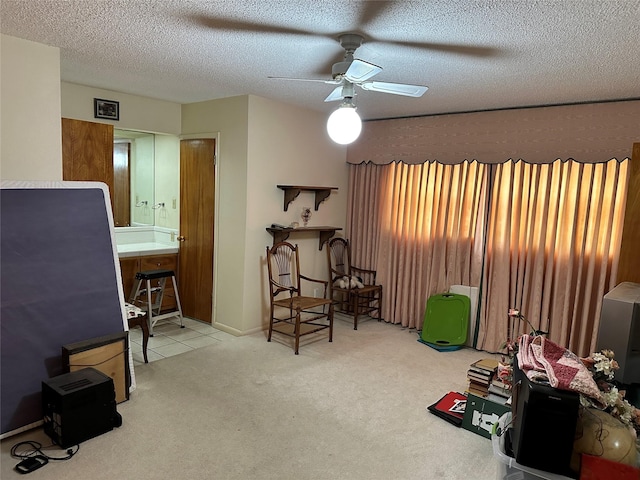 living area featuring a ceiling fan, carpet flooring, and a textured ceiling