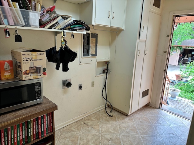 laundry area with hookup for an electric dryer, electric panel, cabinet space, baseboards, and washer hookup