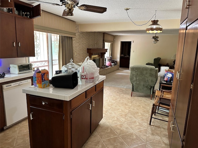 kitchen featuring open floor plan, white dishwasher, tile counters, and a ceiling fan