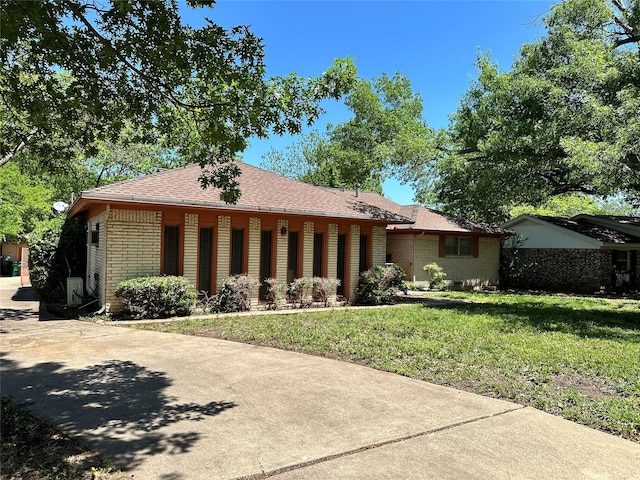 single story home with a front lawn and roof with shingles