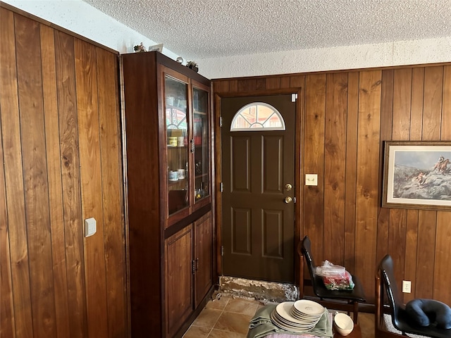 entryway featuring wooden walls and a textured ceiling