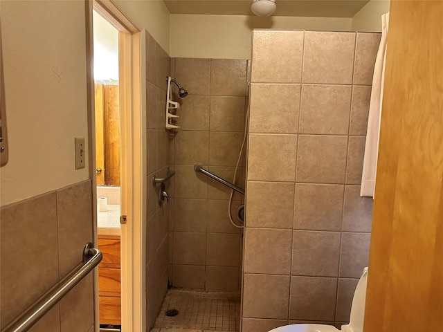bathroom featuring a tile shower and tile walls