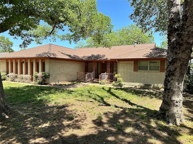 view of front of home with covered porch, a front lawn, and brick siding