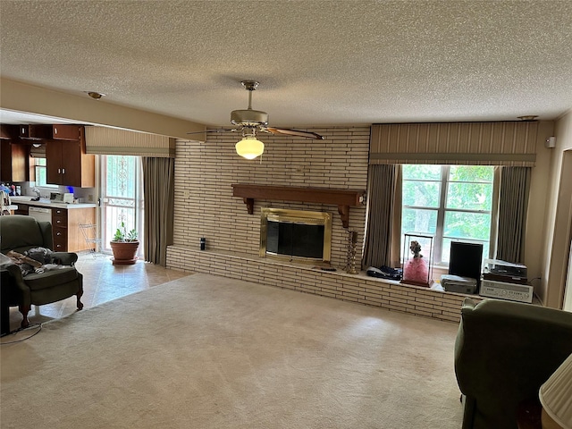 carpeted living area featuring a brick fireplace, a textured ceiling, and a ceiling fan