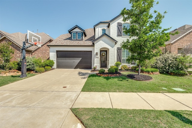 view of front of house with brick siding, a garage, a front yard, and concrete driveway