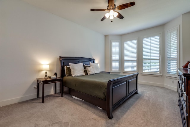 bedroom with light colored carpet, baseboards, and multiple windows