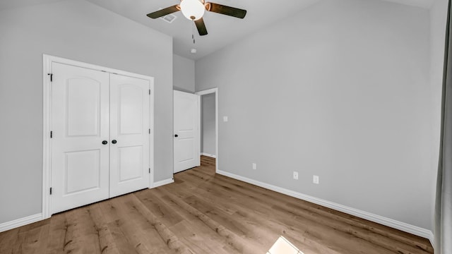 unfurnished bedroom featuring wood finished floors, baseboards, a closet, and ceiling fan